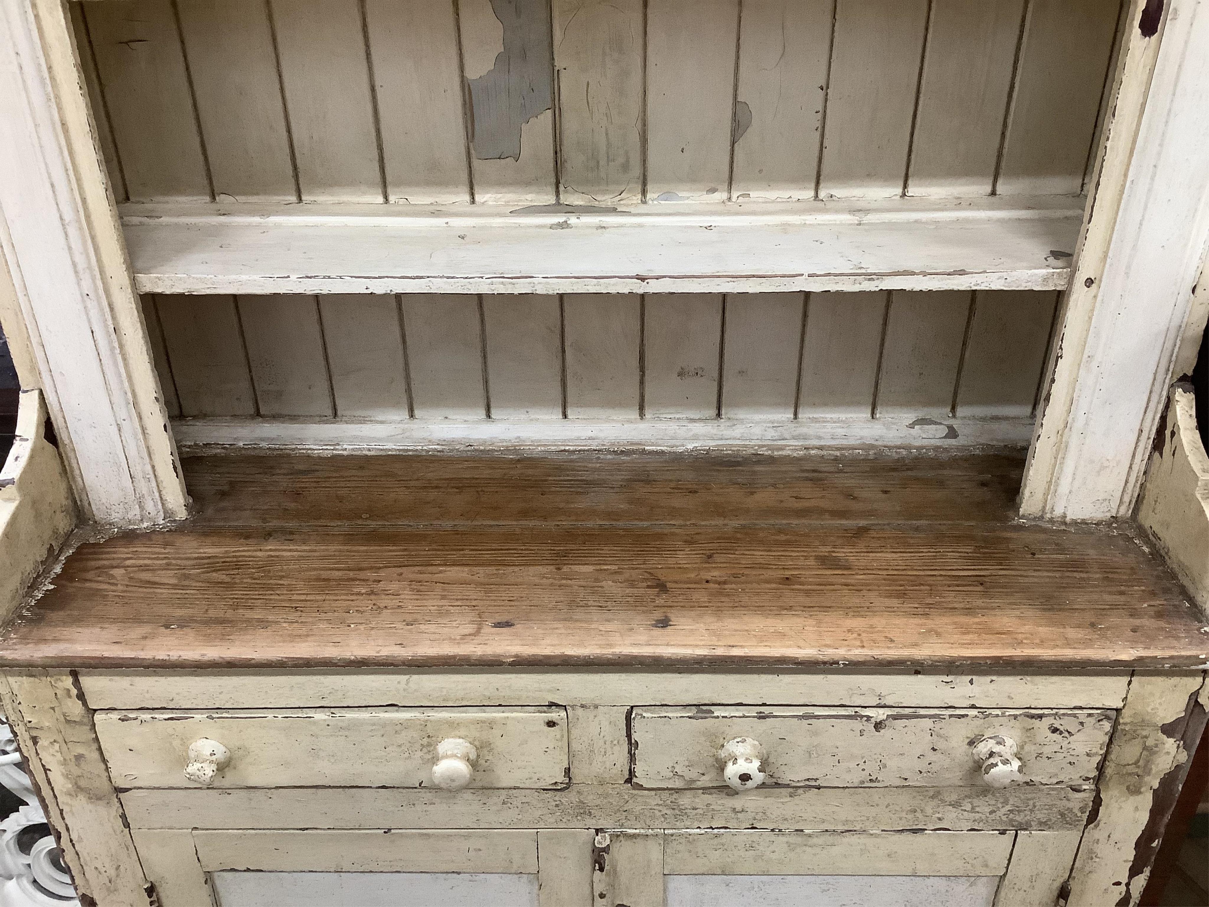 An early 19th century Irish painted pine dresser with boarded rack, width 126cm, depth 49cm, height 210cm. Condition - fair